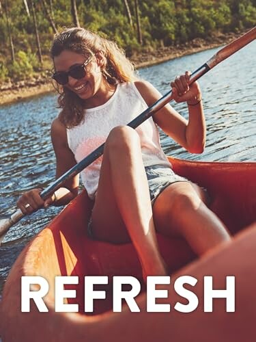 Woman kayaking on a lake, smiling and wearing sunglasses